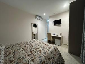 a bedroom with a bed and a desk and a television at La Suite in Cassino