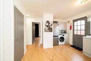 an open kitchen and living room with a washer and dryer at Ellaburn in Barry