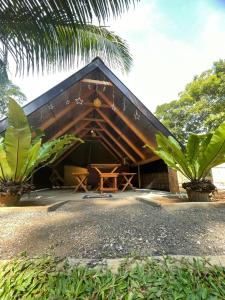 a building with a triangular roof with a table in front at Elephant Cabana Udawalawe in Udawalawe