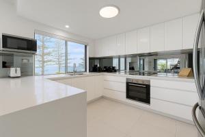a large white kitchen with white cabinets and appliances at Golden Beach Oceanfront 3BR in Golden Beach