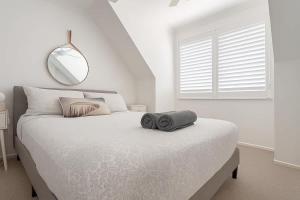 a white bedroom with a large bed with a mirror at Golden Beach Oceanfront 3BR in Golden Beach