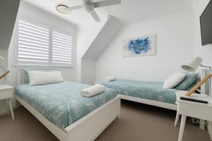 a white bedroom with a bed and a window at Golden Beach Oceanfront 3BR in Golden Beach