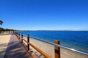 a fence on a beach next to the water at Golden Beach Oceanfront 3BR in Golden Beach