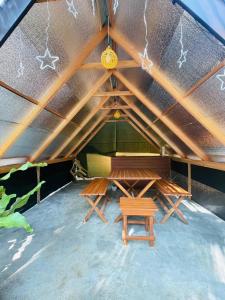 a room with a table and benches in a tent at Elephant Cabana Udawalawe in Udawalawe