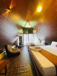 a room with three beds and a chair in it at Elephant Cabana Udawalawe in Udawalawe
