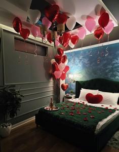 a room with a bed with red and pink balloons at Laci lak modern apartment in Oradea