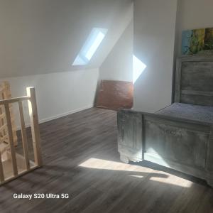 an attic room with a bed and a staircase at Maison typique picarde in Soissons