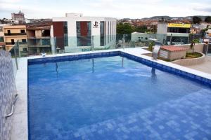 a large blue swimming pool on top of a building at Hotel Center Vitoria in Vitória de Santo Antão +16 photos