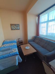 a room with a couch and a bed and a table at Hotel Avion in Prostějov