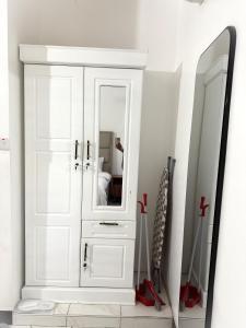 a white cabinet with a mirror in a room at Dana's Room in Dar es Salaam