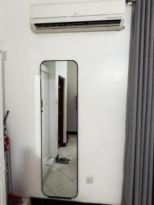 a mirror on a wall with a air conditioner at Dana's Room in Dar es Salaam