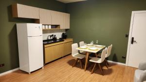 a kitchen with a table with chairs and a refrigerator at Studio Cotia Próximo ao Thermas da Mata, Animalia Park e CT São Paulo in Cotia +5 photos