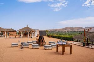 an outdoor area with couches and a table and chairs at Kalyptus Luxury Camp in Lalla Takerkoust