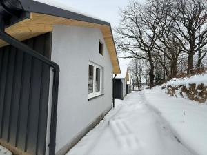 a snow covered sidewalk next to a house at Hotel Mis in Bochnia