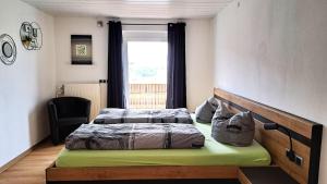 a bedroom with two beds and a window at FeWo Beim Huber in Hopferau