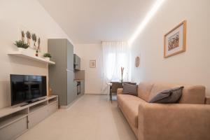 a living room with a couch and a television at Alloggio Primula - Gionic Apartments Bologna in Bologna