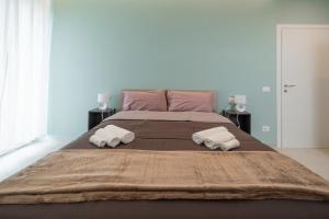 a large bed with two rolled up towels on it at Alloggio Primula - Gionic Apartments Bologna in Bologna