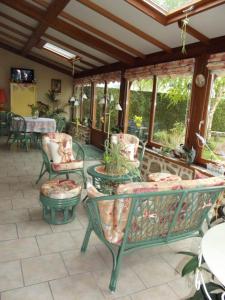 a patio with chairs and tables and windows at Chambres d'hôtes La Poudrière in Argentan