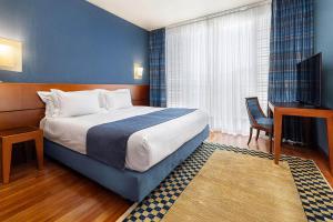 a hotel room with a bed and a desk at B&B HOTEL Imperia Rossini al Teatro in Imperia