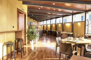 a restaurant with tables and chairs in a room at B&B HOTEL Imperia Rossini al Teatro in Imperia