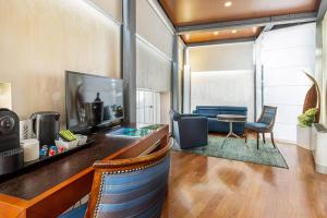 a living room with a blue couch and a tv at B&B HOTEL Imperia Rossini al Teatro in Imperia +13 photos