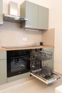 a kitchen with an oven with dishes in it at Alloggio Primula - Gionic Apartments Bologna in Bologna +27 photos
