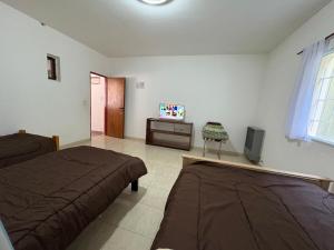 a bedroom with two beds and a television in it at Suarez home in Puerto Madryn +11 photos