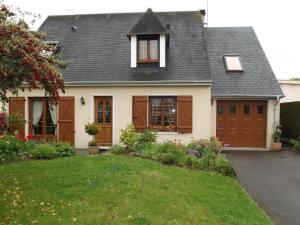 a house with brown doors and a yard at Chambres d'hôtes La Poudrière in Argentan