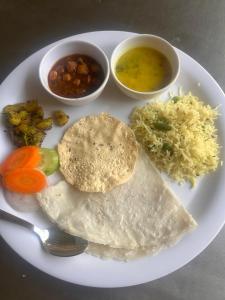 a white plate of food with a tortilla and bowls of food at Glory of MJ, Family Resort in Nature, Panvel in Panvel