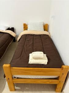 a bed with a wooden frame in a room at Suarez home in Puerto Madryn