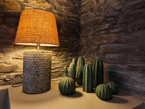 a lamp sitting on a table next to a group of cactus at Carpe Diem Suite in Agios Fokas