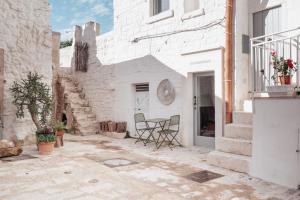 a patio with a table and chairs in a building at Corte Giotto Exclusive House in Carovigno