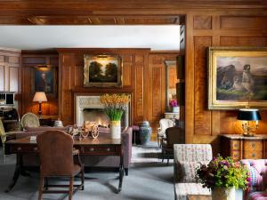 a living room with a table and a fireplace at Covent Garden Hotel, Firmdale Hotels in London