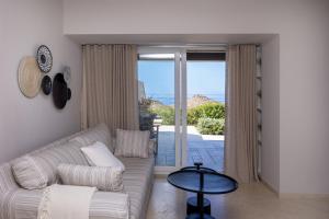 a living room with a couch and a view of the ocean at Carpe Diem Suite in Agios Fokas