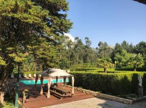 a wooden deck with an umbrella next to a swimming pool at Villas do monte in Guimarães