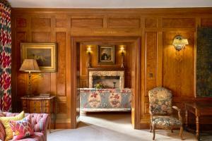 a living room with a fireplace and a chair at Covent Garden Hotel, Firmdale Hotels in London