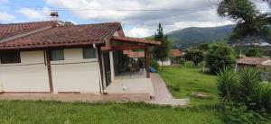 a small white house with a dog in the doorway at Gästehaus Samaipata in Samaipata