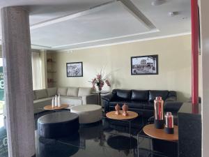 a living room with a couch and two tables at Hotel Center Vitoria in Vitória de Santo Antão