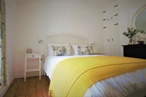 a bedroom with a bed with a yellow blanket at 2 Bed in Swanage oc-wy460 in Swanage
