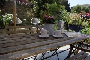 a wooden picnic table with two cups on it at 2 Bed in Swanage oc-wy460 in Swanage