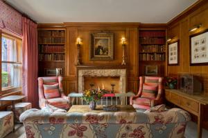 a living room with a fireplace and a table and chairs at Covent Garden Hotel, Firmdale Hotels in London +17 photos