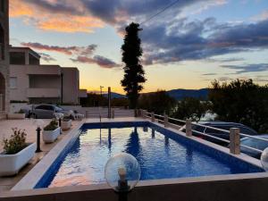 a swimming pool with a sunset in the background at Villa Ana in Slatine