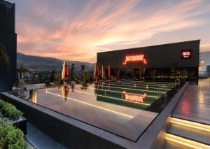 a building with a pool in front of a restaurant at Radisson RED Izmir Point Bornova in İzmir