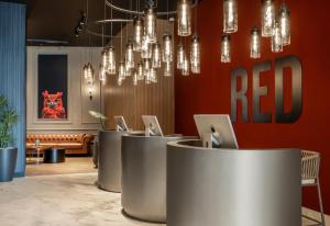 a lobby with a row of tables with laptops at Radisson RED Izmir Point Bornova in İzmir +38 photos