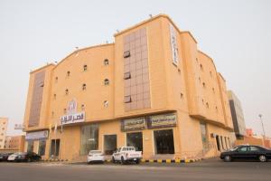 un grande edificio con macchine parcheggiate di fronte di Qsr Al Lolo a Al Fayşalīyah
