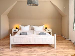 a white bed in a room with two night stands at GurkenLoft in Lübbenau