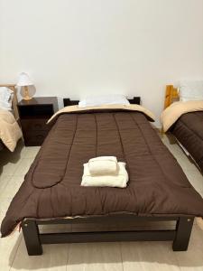 a bed with two towels on it in a room at Suarez home in Puerto Madryn