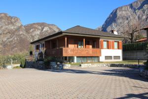 a house with a brick driveway in front of a mountain at LA MUELE Affittacamere in Gemona del Friuli