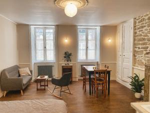 a living room with a couch and a table and chairs at Les volets verts in Pont-Croix