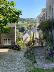 a cobblestone street in a village with buildings at Les volets verts in Pont-Croix